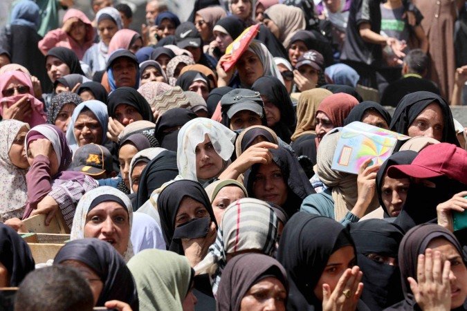 Mulheres palestinas fazem fila para receber sacos de farinha em depósito do Programa Mundial de Alimentos da ONU, em Gaza - (crédito: AFP) Mulheres palestinas fazem fila para receber sacos de farinha em depósito do Programa Mundial de Alimentos da ONU, em Gaza - (crédito: AFP)