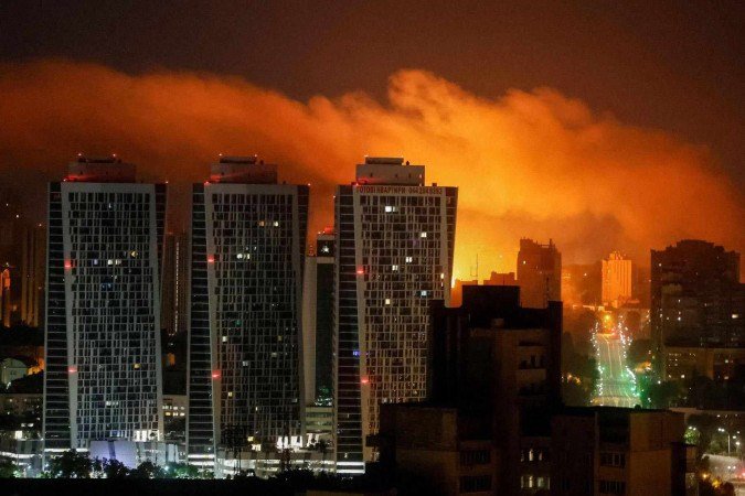 Morador de Kiev observa incêndio em prédio após ataque: bombardeios têm se intensificado -  (crédito: Getty Images)