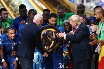 O presidente da FIFA, Gianni Infantino, e o presidente dos EUA, Donald Trump, entregam o troféu ao zagueiro inglês número 24 do Chelsea, Reece James, durante a cerimônia de premiação dos Campeões da Copa do Mundo de Clubes da FIFA 2025       -  (crédito: FRANCK FIFE/AFP)