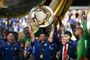 O zagueiro inglês do Chelsea, Reece James, ergue o troféu enquanto seus companheiros de equipe e o presidente dos EUA, Donald Trump, aplaudem durante a cerimônia de premiação dos campeões da Copa do Mundo de Clubes da FIFA 2025       -  (crédito: Brendan SMIALOWSKI/AFP)
