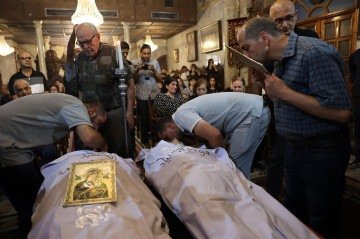 Palestinos cristãos participam do funeral de Saad Salameh e de Foumia Ayyad, dois fiéis católicos mortos durante o bombardeio israelense -  (crédito: Fotos: Omar Al-Qattaa/AFP)