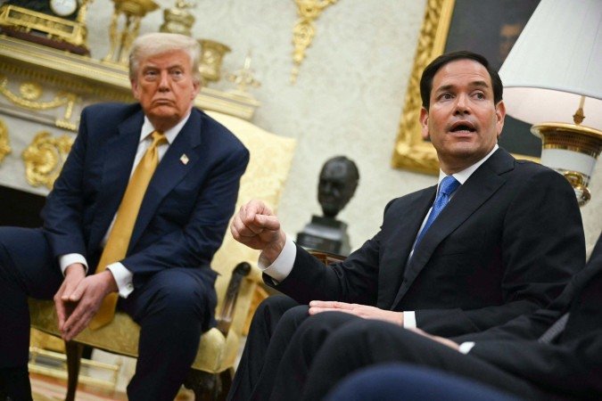 US President Donald Trump listens to Secretary of State Marco Rubio speak during a meeting in the Oval Office of the White House in Washington, DC, on July 16, 2025.  -  (crédito: ANDREW CABALLERO-REYNOLDS / AFP)