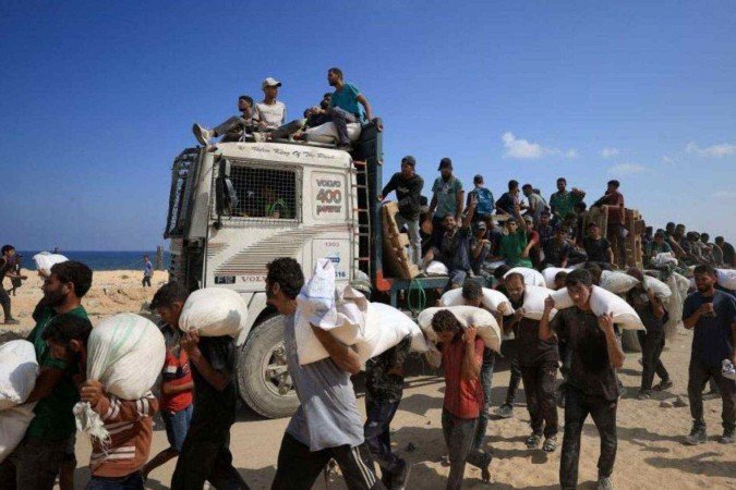 Caminhões transportando ajuda humanitária com a marca da GHF são vistos na passagem de Kerem Shalom entre Israel e Gaza, no lado israelense -  (crédito: Reuters)