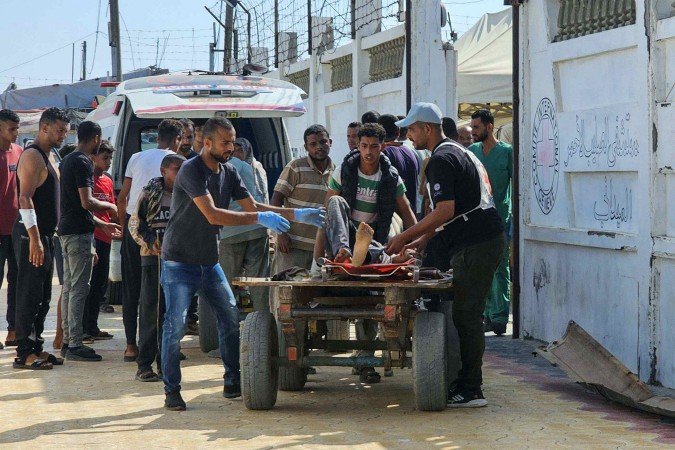 Palestinos transportam feridos enquanto tentavam obter ajuda humanitária para o hospital de campanha da Cruz Vermelha na área de Mawasi, em Rafah, no sul da Faixa de Gaza, em 20 de julho de 2025 - (crédito: Agência France-Press) Palestinos transportam feridos enquanto tentavam obter ajuda humanitária para o hospital de campanha da Cruz Vermelha na área de Mawasi, em Rafah, no sul da Faixa de Gaza, em 20 de julho de 2025 - (crédito: Agência France-Press)