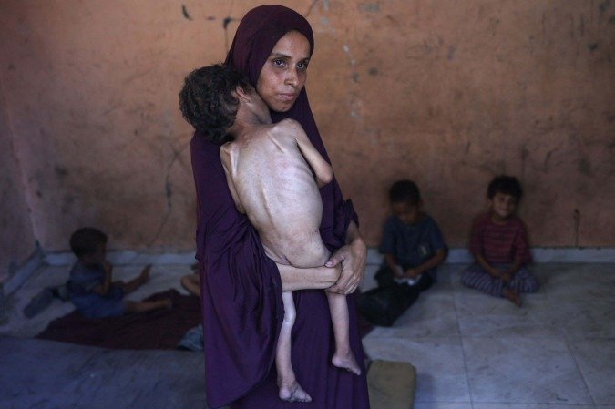 Naema, mãe palestina de 30 anos, segura o filho Yazan, no campo de refugiados de Al-Shati, a oeste da Cidade de Gaza - (crédito: Omar Al-Qataa/AFP) Naema, mãe palestina de 30 anos, segura o filho Yazan, no campo de refugiados de Al-Shati, a oeste da Cidade de Gaza - (crédito: Omar Al-Qataa/AFP)