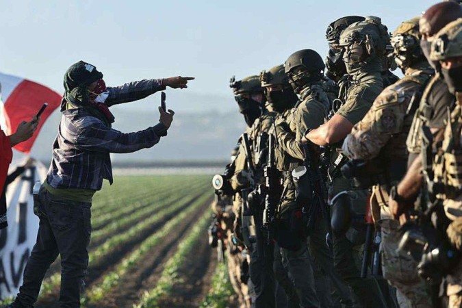 As batidas migratórias em Los Angeles são marcadas por confrontos violentos entre a população e agentes federais - (crédito: Apu Gomes/Getty Images) As batidas migratórias em Los Angeles são marcadas por confrontos violentos entre a população e agentes federais - (crédito: Apu Gomes/Getty Images)