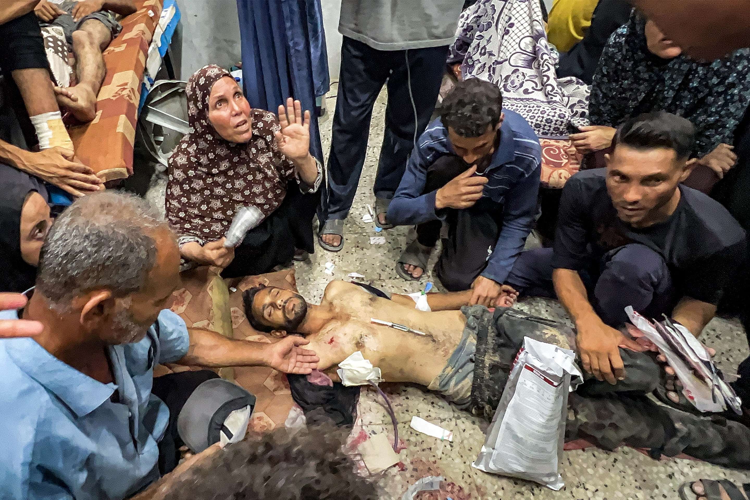 Palestinos tentam socorrer vítima de disparos à espera de caminhões com mantimentosm na passagem de Zikim 