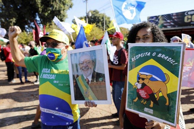  People hold allusive signs during a demonstration called by the National Student Union (UNE) against US government trade taxes and sanctions on Brazil, in front of the US embassy in Brasilia on August 1, 2025. Trump’s Brazil tariff is among the highest imposed on US trading partners, and unlike with other countries, the measures have been framed in openly political terms, sweeping aside centuries-old trade ties and a surplus that Brasilia put at $284 million last year. (Photo by SERGIO LIMA / AFP)      