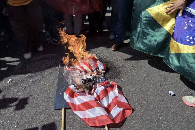  Demonstrators burn a US flag and a picture of US President Donald Trump during a protest in defence of national sovereignty following the US government trade taxes and sanctions on Brazil, near the US consulate, in Sao Paulo, Brazil, on August 1, 2025. Trump’s Brazil tariff is among the highest imposed on US trading partners, and unlike with other countries, the measures have been framed in openly political terms, sweeping aside centuries-old trade ties and a surplus that Brasilia put at $284 million last year. (Photo by NELSON ALMEIDA / AFP)      