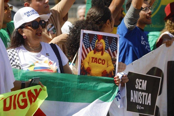 Manifestante em frente à embaixada exibe meme de Trump
- (crédito: Sergio Lima/AFP) Manifestante em frente à embaixada exibe meme de Trump
- (crédito: Sergio Lima/AFP)