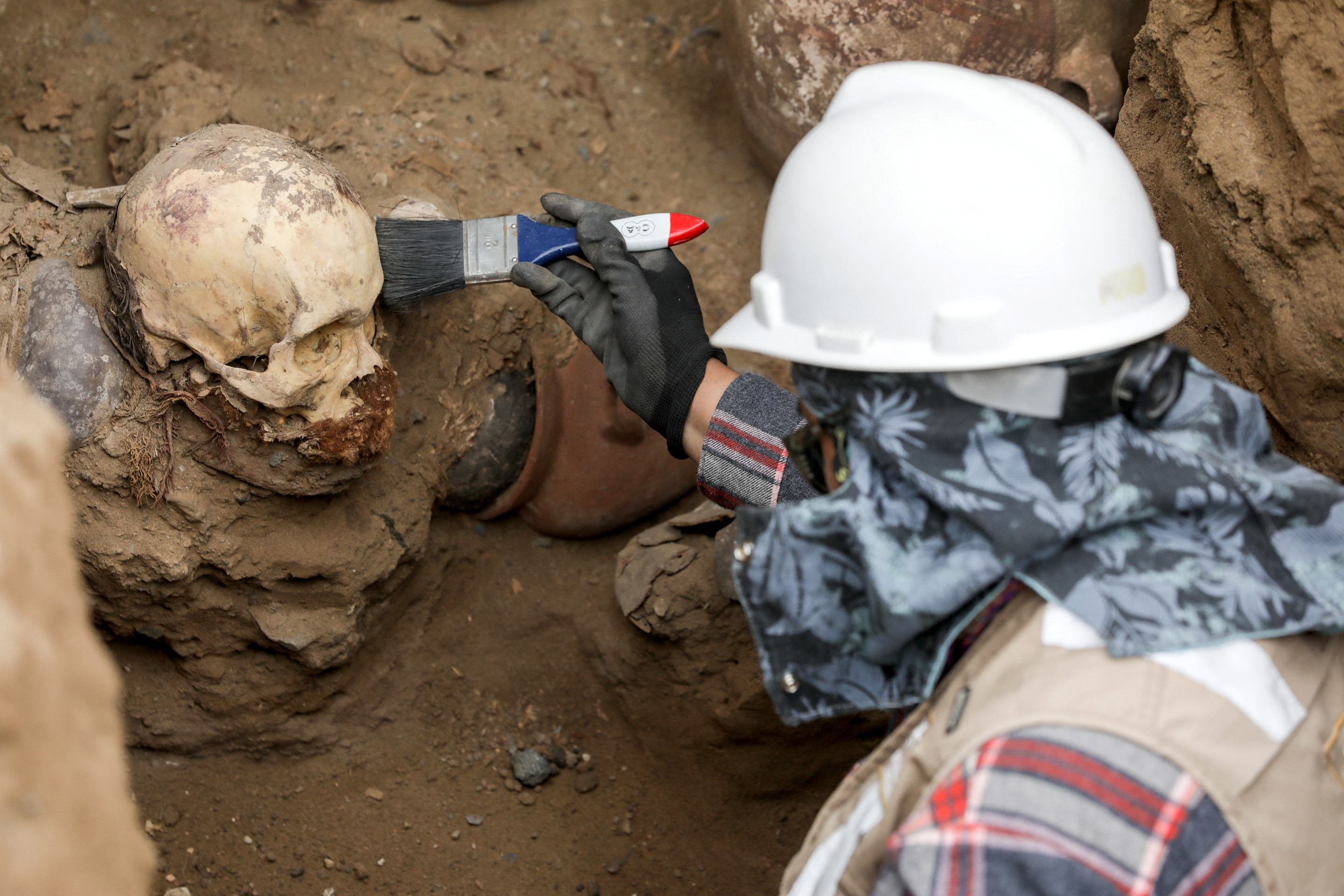 Vista de um crânio e artefatos encontrados em uma tumba antiga atribuída à cultura pré-inca Chancay, desenterrada acidentalmente por trabalhadores que instalavam um gasoduto no distrito de Puente Piedra, em Lima, em 31 de julho de 2025      