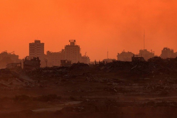 Foto tirada ao pôr-do-sol a partir da fronteira sul de Israel mostra prédios destruídos por bombardeios na Faixa de Gaza - (crédito: Jack Guaez/AFP) Foto tirada ao pôr-do-sol a partir da fronteira sul de Israel mostra prédios destruídos por bombardeios na Faixa de Gaza - (crédito: Jack Guaez/AFP)