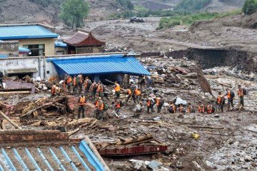  Equipes de resgate atuam em meio à lama e às águas turbulentas após enchentes em Gansu, noroeste da China -  (crédito: AFP)