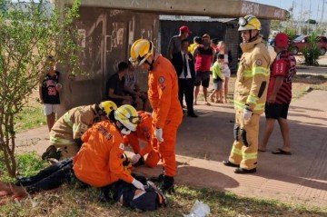 Quatro bombeiros atendem mulher estendida no chão, em parada de ônibus no Pôr do Sol, Ceilândia -  (crédito: Divulgação/CBMDF)
