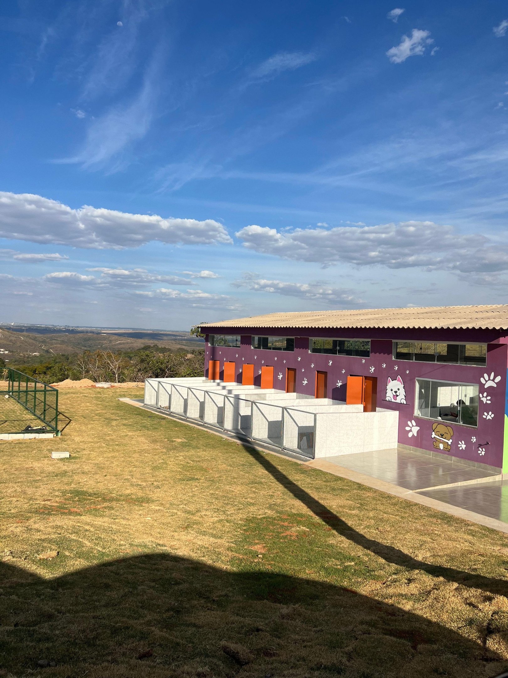 Espaço externo do abrigo com cercas e muros baixos
