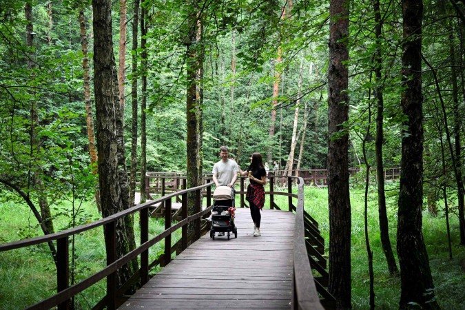  Pedestrians walk in Losiny Ostrov National Park (Elk Island) outside Moscow on August 2, 2025. Russian law prohibits construction in national parks but local authorities got around it by arguing that the project consisted of 