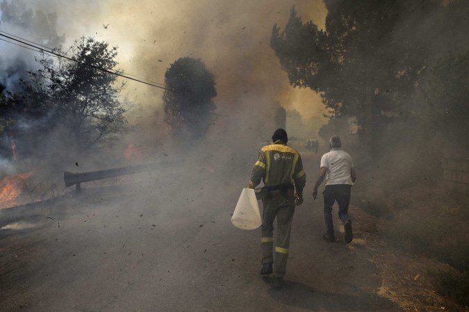 Um incêndio florestal queima perto de um vinhedo na vila de Vilarino, no município de Carballeda de Avia, noroeste da Espanha, em 17 de agosto de 2025.       -  (crédito:  AFP)
