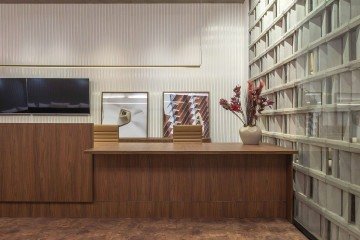 O Lounge Hometeck também tem o ripado branco com acabamento dourado atrás da TV 