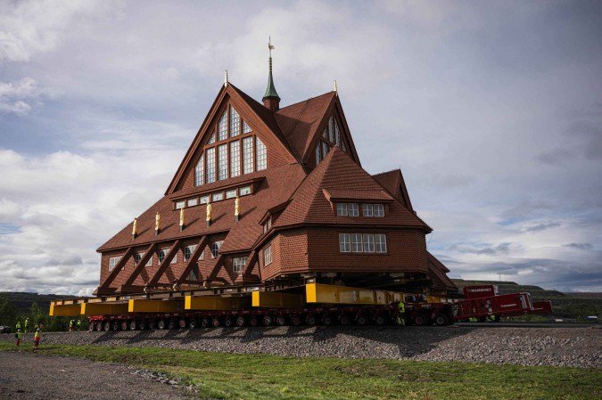 Trabalhadores usam reboques de plataforma com controle remoto e 224 rodas no total para mover a Igreja de madeira de Kiruna, em Kiruna, Suécia, em 19 de agosto de 2025 - (crédito: Jonathan NACKSTRAND/AFP) Trabalhadores usam reboques de plataforma com controle remoto e 224 rodas no total para mover a Igreja de madeira de Kiruna, em Kiruna, Suécia, em 19 de agosto de 2025 - (crédito: Jonathan NACKSTRAND/AFP)