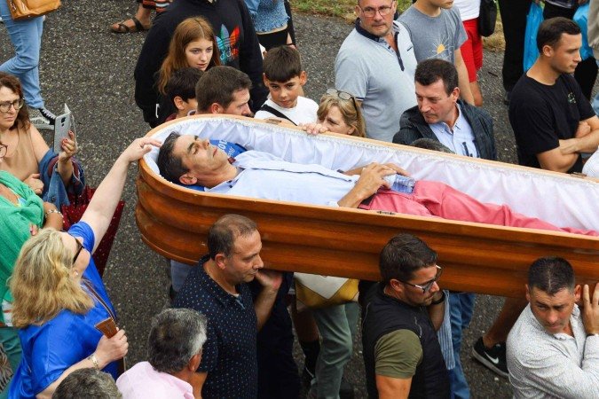 Pessoas levam nos ombros caixões com pessoas vivas no seu interior, durante a procissão de Santa Marta de Ribarteme, em 2019 -  (crédito: MIGUEL RIOPA/AFP via Getty Images)
