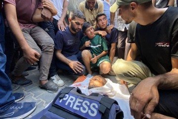 Familiares do fotojornalista palestino Hussam al-Masri, um contratado da Reuters morto em um ataque israelense ao Hospital Nasser, lamentam seu corpo antes de seu funeral em Khan Yunis, no sul da Faixa de Gaza, em 25 de agosto de 2025       -  (crédito:  AFP)