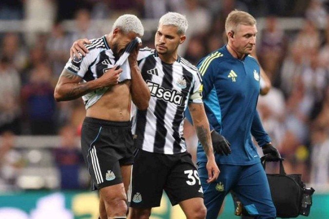 Brasileiro pe consolado pelo amigo Bruno Guimarães - (crédito: Foto: George Wood/Getty Images) Brasileiro pe consolado pelo amigo Bruno Guimarães - (crédito: Foto: George Wood/Getty Images)