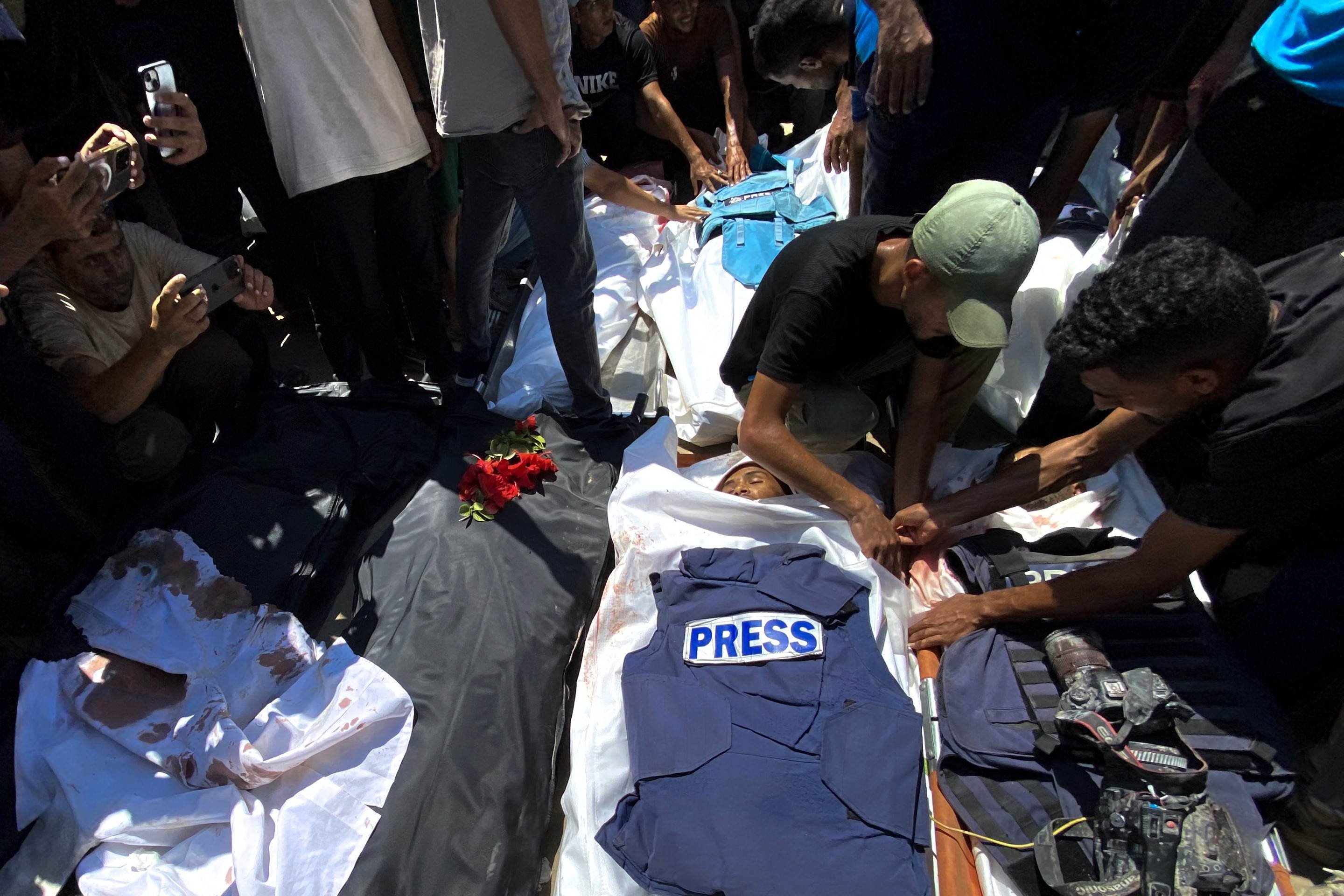Pessoas lamentam os corpos de jornalistas palestinos mortos em um ataque israelense ao Hospital Nasser, antes de seu funeral em Khan Yunis, no sul da Faixa de Gaza, em 25 de agosto de 2025      