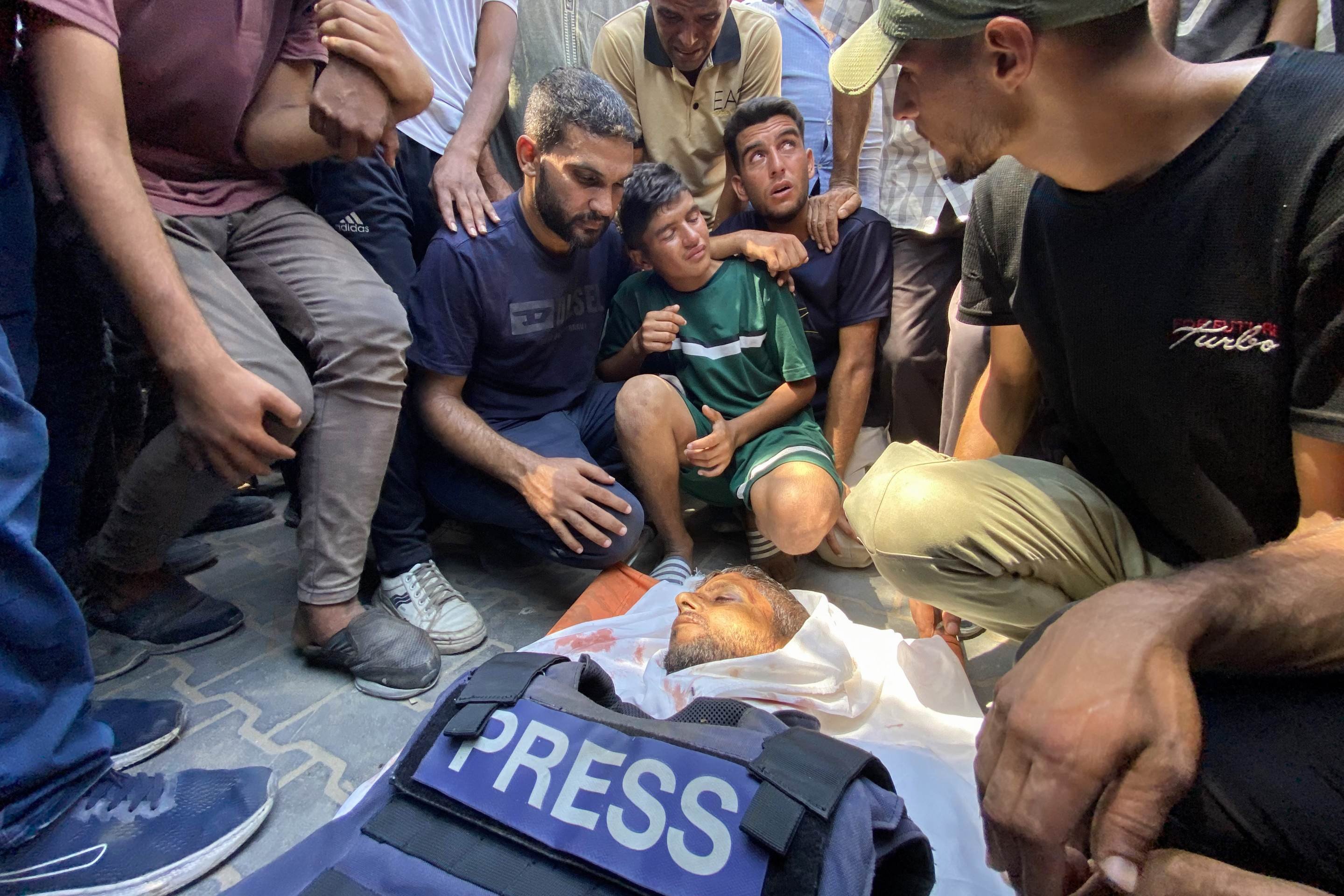 Familiares do fotojornalista palestino Hussam al-Masri, um contratado da Reuters morto em um ataque israelense ao Hospital Nasser, lamentam seu corpo antes de seu funeral em Khan Yunis, no sul da Faixa de Gaza, em 25 de agosto de 2025      