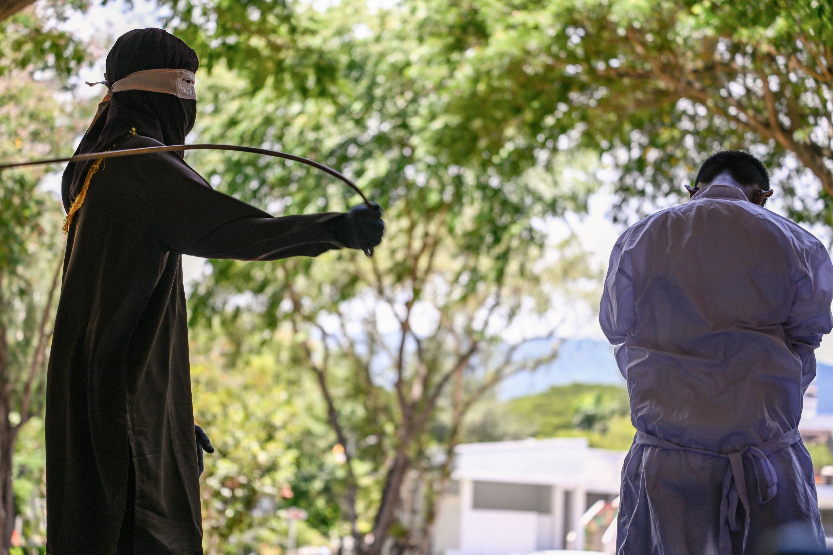 Um homem condenado por praticar sexo gay é açoitado publicamente por um membro da polícia da Sharia em Banda Aceh, em 26 de agosto de 2025      