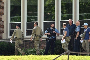 Policiais periciam o local do tiroteio, na Escola Católica Anunciação, em Minneapolis: tiros de fuzil disparados pela janela  -  (crédito: Tom Baker/AFP)