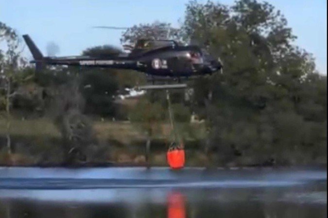 Helicóptero cai em lago ao tentar coletar água - (crédito: Reprodução/Redes Sociais ) Helicóptero cai em lago ao tentar coletar água - (crédito: Reprodução/Redes Sociais )