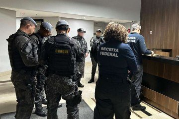 Policiais fazem segurança durante operação contra lavagem de dinheiro em São Paulo. Grupo investigado teria ligação com o PCC, segundo promotores. -  (crédito:  AFP)