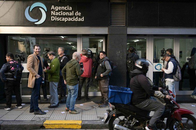Jornalistas aguardam do lado de fora da Agência Nacional de Deficiência (Andis), durante revista de policiais, em Buenos Aires - (crédito: Juan Mabromata/AFP) Jornalistas aguardam do lado de fora da Agência Nacional de Deficiência (Andis), durante revista de policiais, em Buenos Aires - (crédito: Juan Mabromata/AFP)