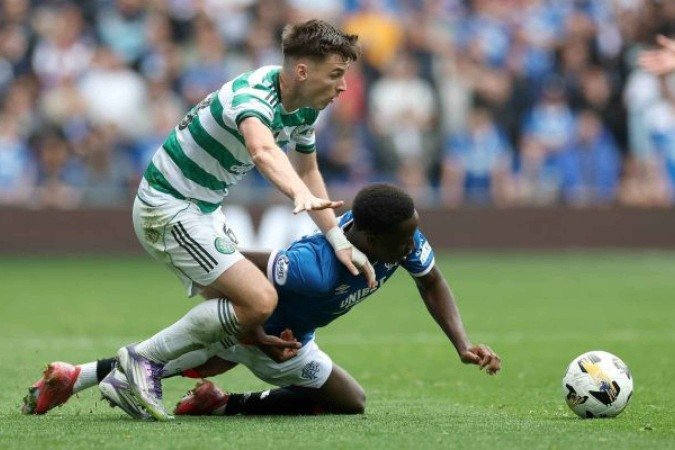 Gassama (Rangers, de azul).disputa a bolacom Tierney (Celtic), Clássico fica no 0 a 0 -  (crédito: Foto: Ian MacNicol/Getty Images)