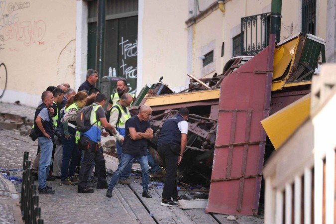 A polícia investiga os destroços do Elevador da Glória um dia após o acidente que matou 17 pessoas em Lisboa -  (crédito: PATRICIA DE MELO MOREIRA/AFP)