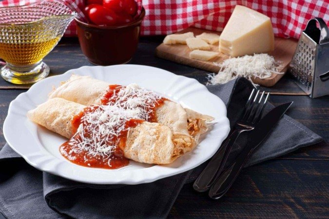 Panqueca recheada de frango com molho de tomate (Imagem: flanovais | Shutterstock) - (crédito: EdiCase) Panqueca recheada de frango com molho de tomate (Imagem: flanovais | Shutterstock) - (crédito: EdiCase)