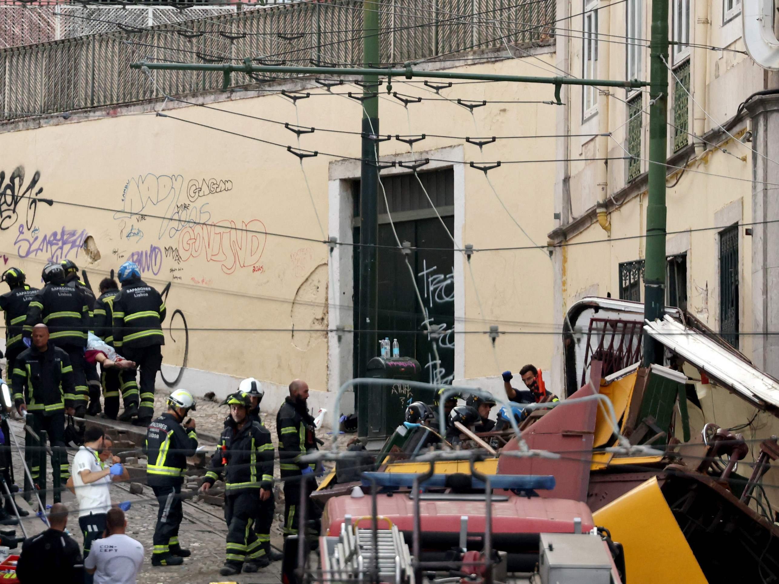 Bombeiros carregam um corpo (acima, à esquerda) em uma maca no local do acidente com o funicular da Glória, em Lisboa, em 3 de setembro de 2025      