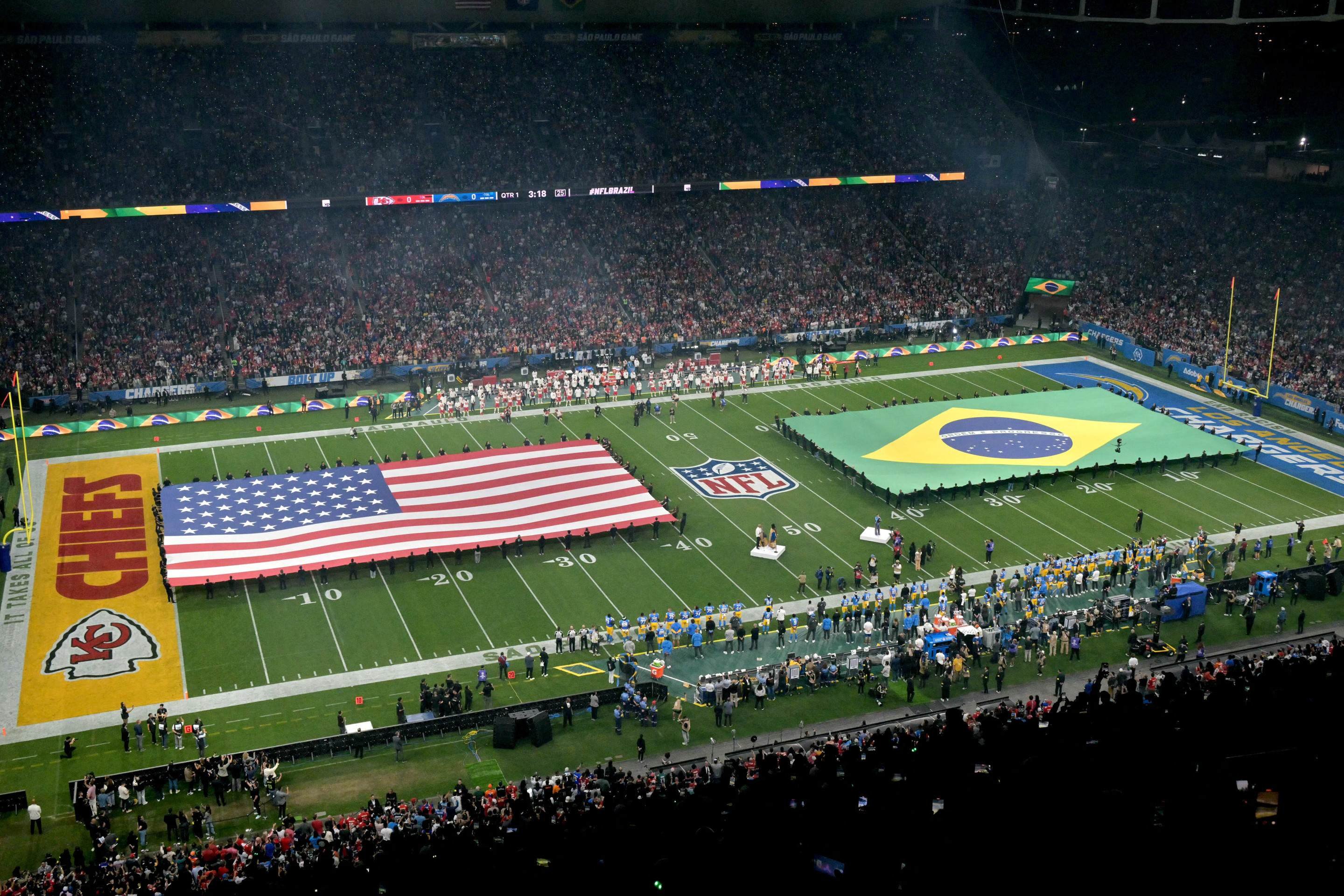 Bandeiras gigantes dos EUA e do Brasil são exibidas no campo antes do jogo da NFL entre o Kansas City Chiefs e o Los Angeles Chargers no Estádio Neo Química Arena em São Paulo