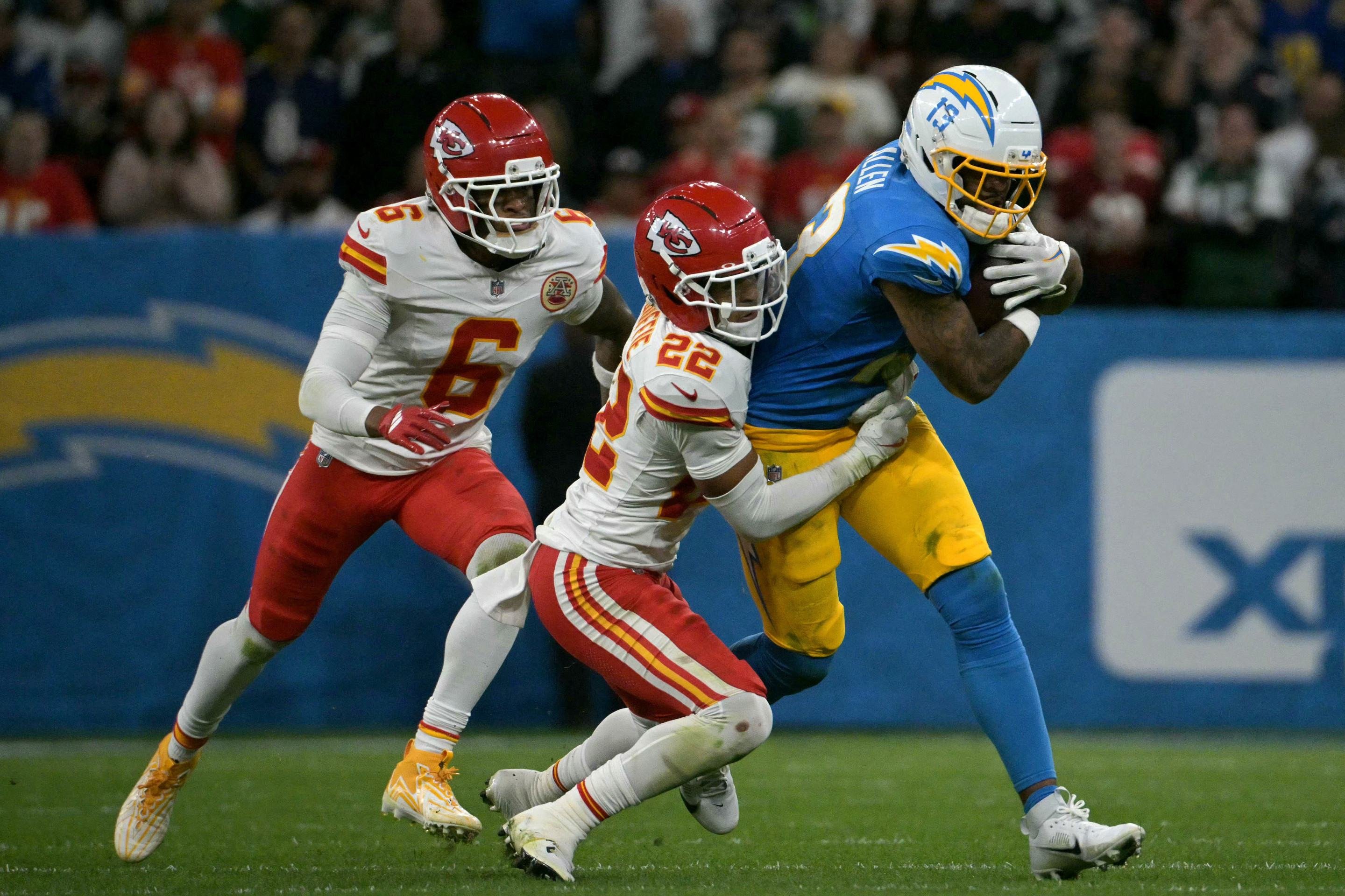 O wide receiver #13 do Los Angeles Chargers, Keenan Allen, é derrubado pelo cornerback #22 do Kansas City Chiefs, Trent McDuffie, durante o jogo da NFL entre o Kansas City Chiefs e o Los Angeles Chargers no Estádio Neo Química Arena