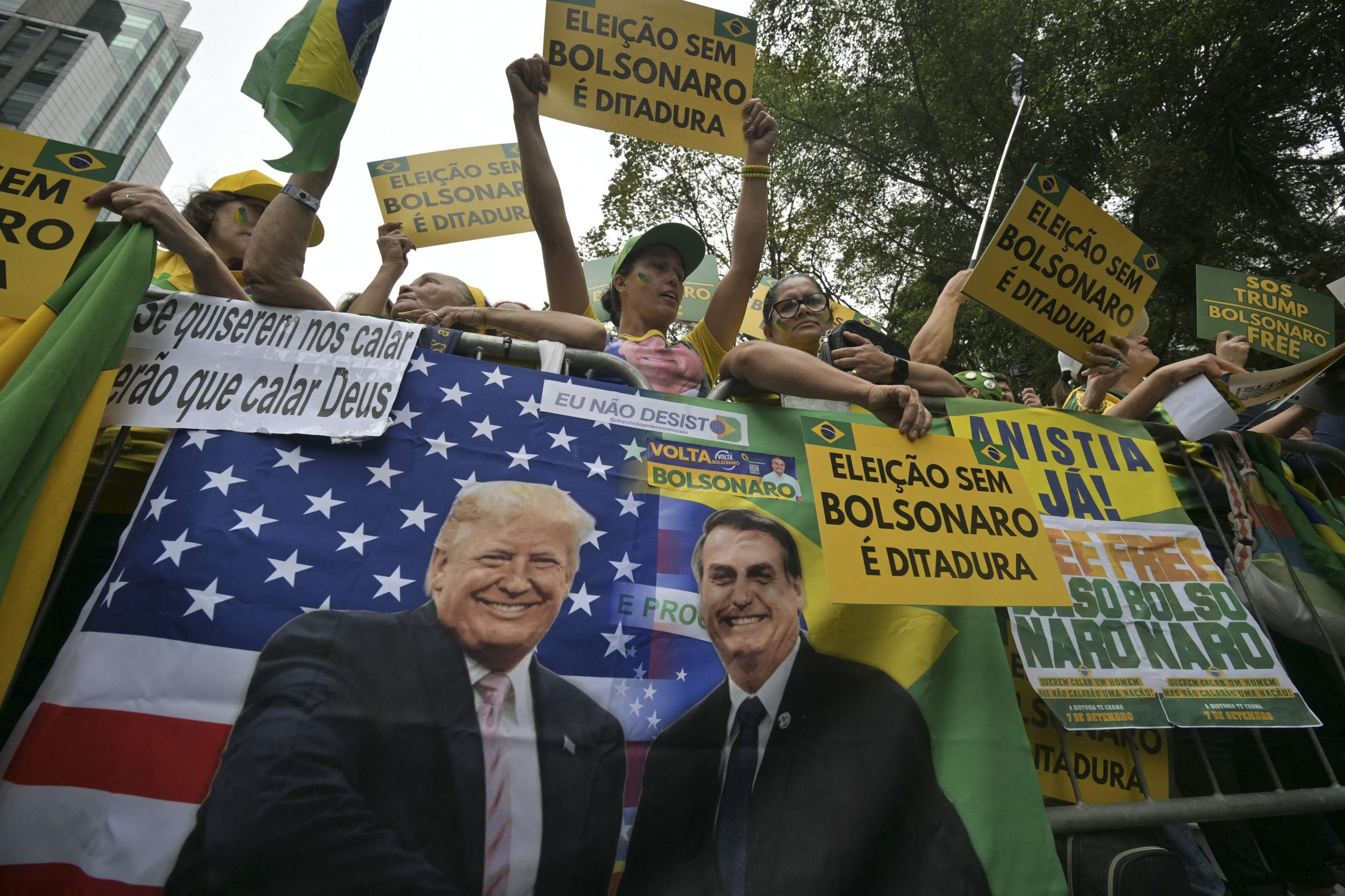 Apoiadores do ex-presidente brasileiro (2019-2022) Jair Bolsonaro, em julgamento por sua suposta participação em uma tentativa de golpe, seguram cartazes alusivos em uma manifestação durante o Dia da Independência