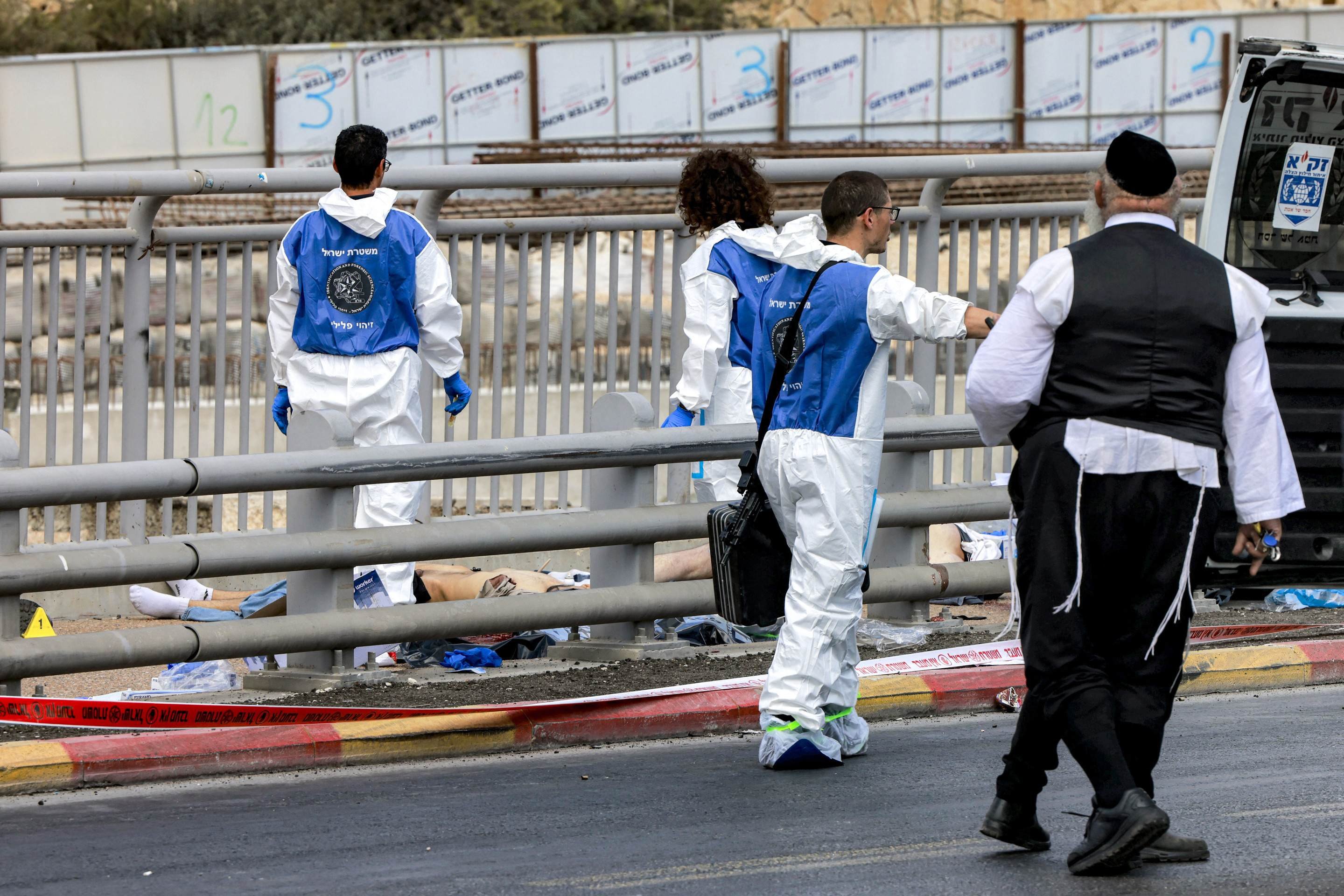 Equipe forense da polícia israelense inspeciona um corpo no local de um tiroteio no cruzamento da estrada Ramot, em Jerusalém Oriental anexada a Israel, em 8 de setembro de 2025      