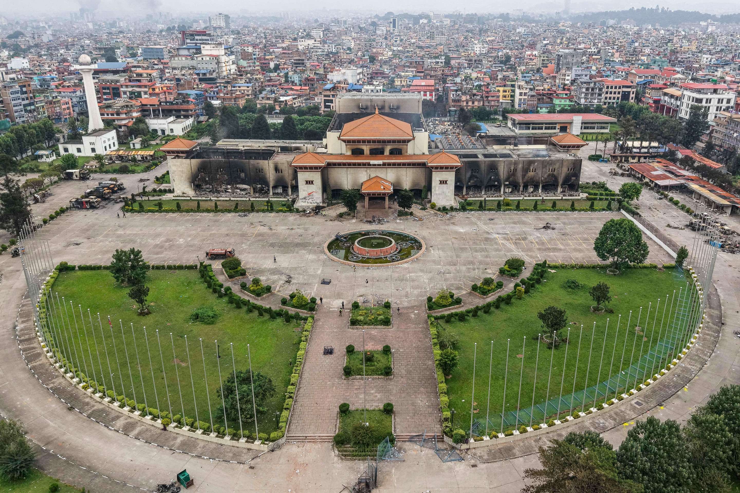 Uma vista aérea mostra o prédio do Parlamento incendiado em Katmandu em 10 de setembro de 2025. Manifestantes nepaleses incendiaram o parlamento em 9 de setembro, enquanto o veterano primeiro-ministro renunciou, enquanto um movimento de protesto da 