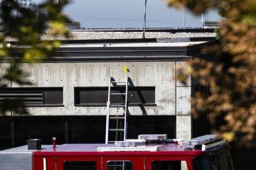 Marcadores de evidências colocados sobre o telhado e a fachada de prédio, na cena do crime