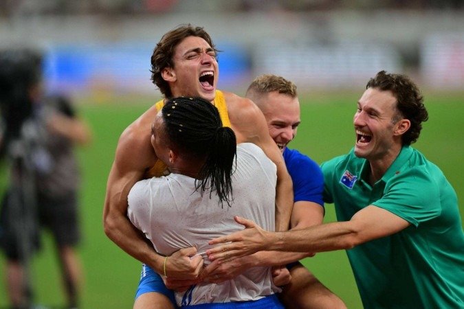 O abraço de parte dos concorrentes em Armand Duplantis após a quebra de novo recorde mundial - (crédito: Andrej Isakovic/AFP) O abraço de parte dos concorrentes em Armand Duplantis após a quebra de novo recorde mundial - (crédito: Andrej Isakovic/AFP)