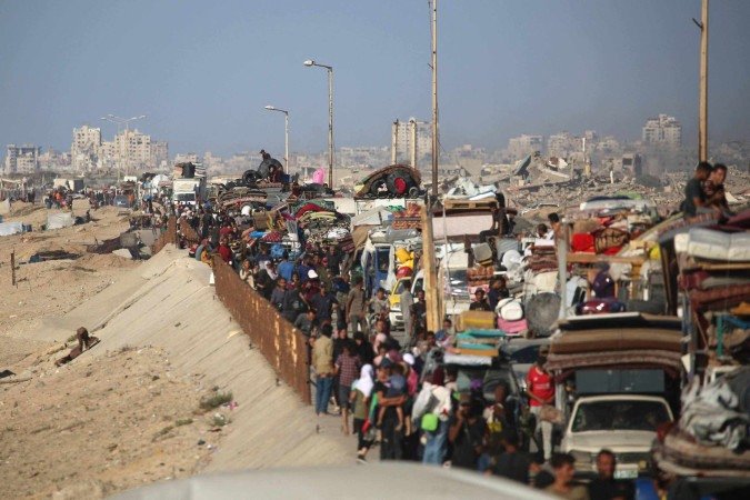  Displaced Palestinians move with their belongings southwards on a road in the Nuseirat refugee camp area in the central Gaza Strip following renewed Israeli evacuation orders for Gaza City on September 16, 2025. Israel launched its long-anticipated ground assault on Gaza City at dawn on September 16, a day after winning backing from its top ally the United States despite mounting international alarm. (Photo by Eyad BABA / AFP)
       -  (crédito:  AFP)
