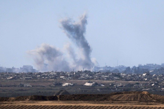 Esta foto, tirada de uma posição na fronteira de Israel com a Faixa de Gaza, mostra a fumaça subindo em meio ao bombardeio israelense ao território palestino sitiado em 16 de setembro de 2025       -  (crédito: MENAHEM KAHANA/AFP)