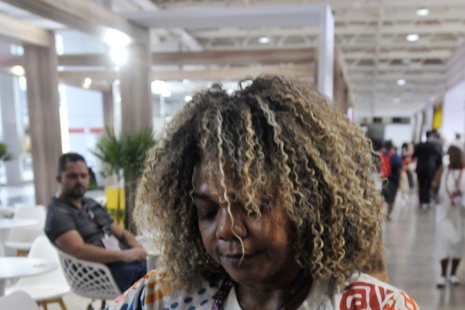 A trancista Chiquinha Aguiar arruma o cabelo do líder religioso Pai Félix durante evento em Brasília