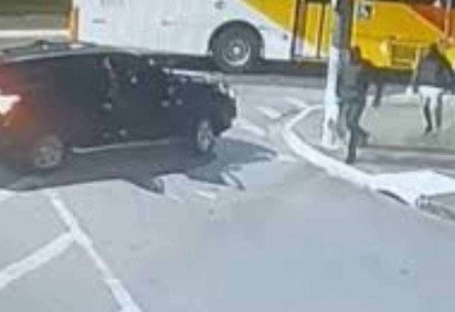 Atiradores retornam ao carro de fuga após executarem o delegado. É possível ver que usam coletes balísticos -  (crédito: Reprodução)