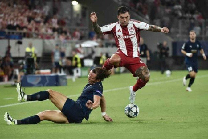 David Luiz tenta um carrinho para evitar um ataque do Olympiacos. Brasileiro se machucou aindano primeiro tempo -  (crédito: Foto: Milos Bicanski/Getty Images)