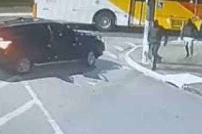 Atiradores retornam ao carro de fuga após executarem o delegado. É possível ver que usam coletes balísticos -  (crédito: Reprodução)
